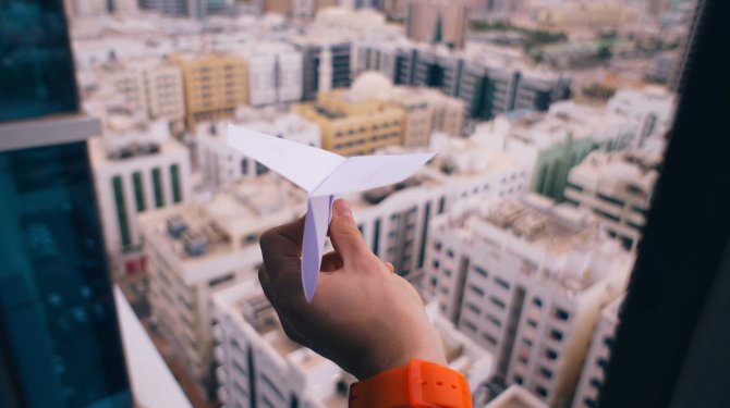 Papierflugzeug über Häuser
