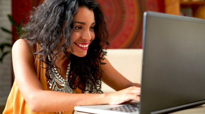 Una mujer sentada frente a un ordenador portátil para una retransmisión por webcam de alcance mundial