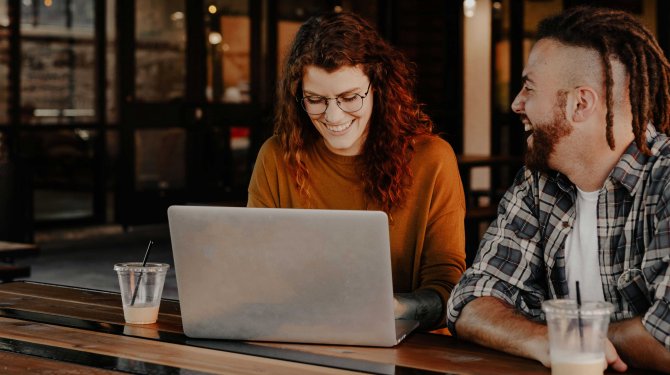 Happy People in front of a Laptop as a symbol for the virtual event entertainment